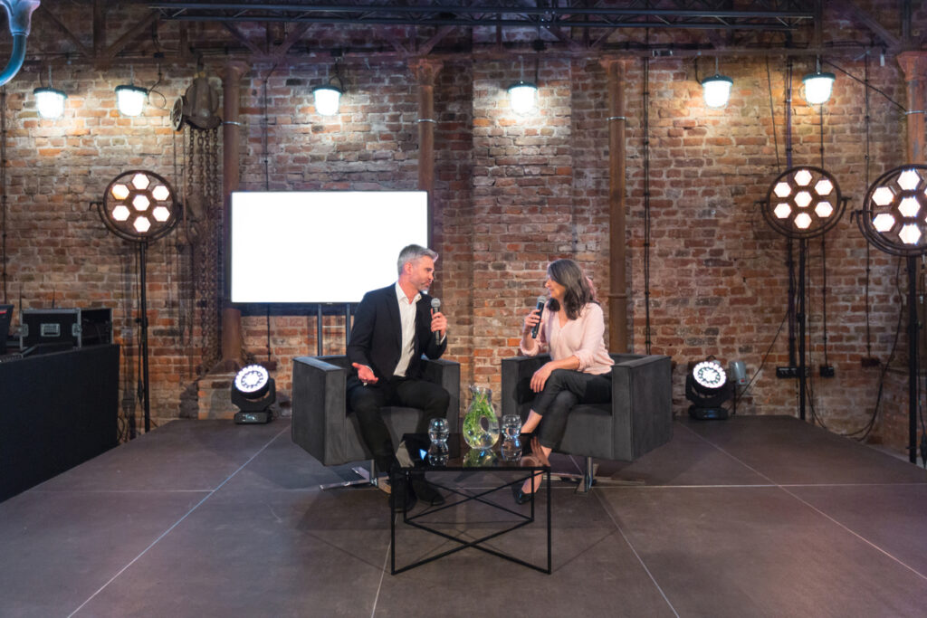 Photo of two professional speakers or panelists on stage at a communications event