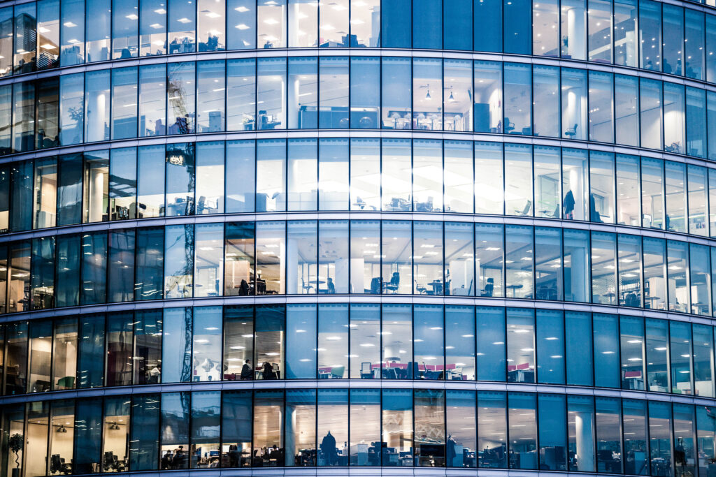 Multi-story building with glass windows showing a large corporate office