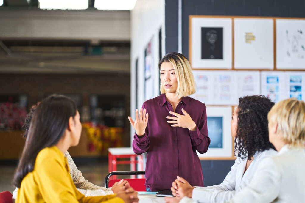 Woman standing while conducting a brand identity workshop with a team of other women